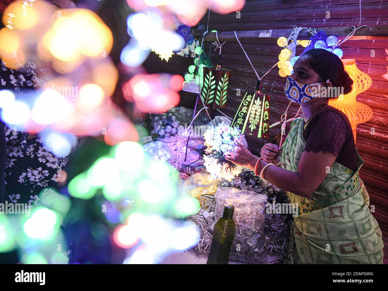 Mumbai, Indien. November 2020. Eine Frau betrachtet elektrische Lichter auf einem Markt vor Diwali, dem hinduistischen Festival der Lichter, inmitten der Verbreitung des COVID-19 in Mumbai, Indien, am 12. November 2020. Quelle: Fariha Farooqui/Xinhua/Alamy Live News Stockfoto