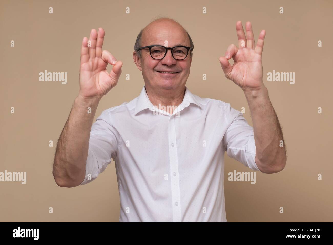 Glücklich reifen Glatze Mann in Brille tun ok Geste. Stockfoto