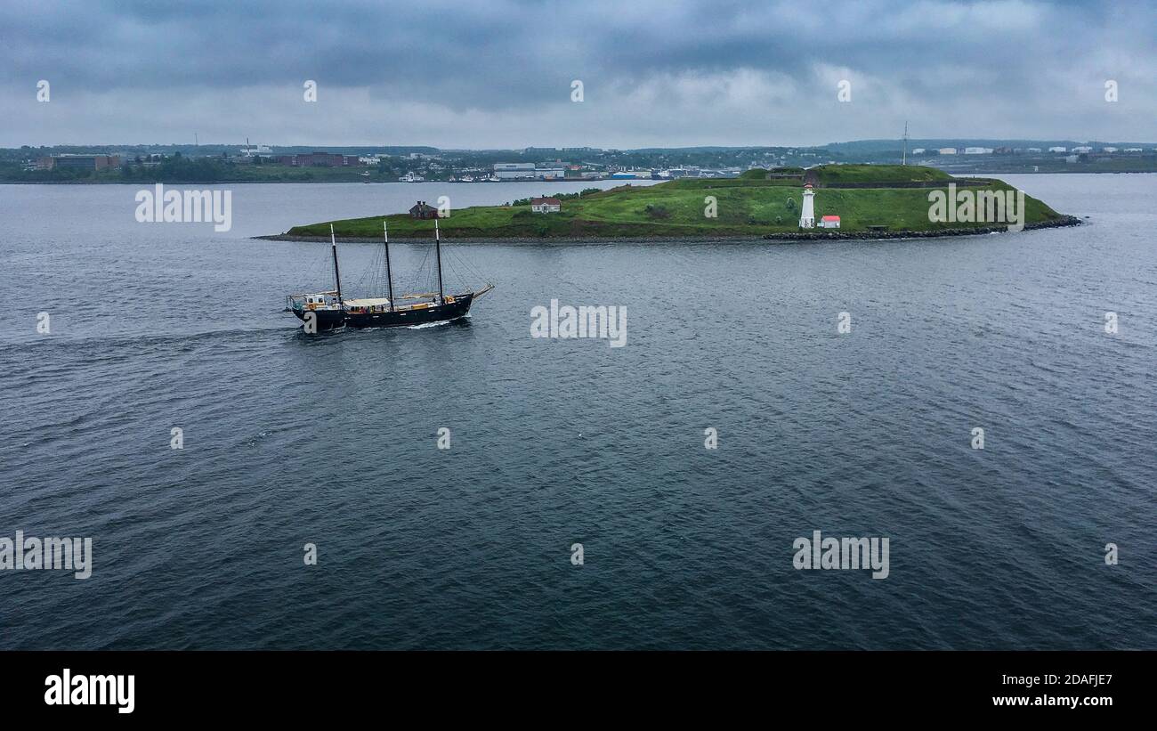 Halifax, Kanada - 18. Juni 2018; drei Mast hohe Segelschiff Pässe vor Georges Island mit rot überdachten weißen Leuchtturm auf dem Weg zum Meer Stockfoto