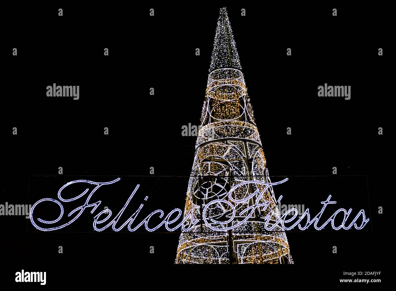 Weihnachtsbaum beleuchtet neben dem Text Happy Holidays geschrieben Auf Spanisch Stockfoto