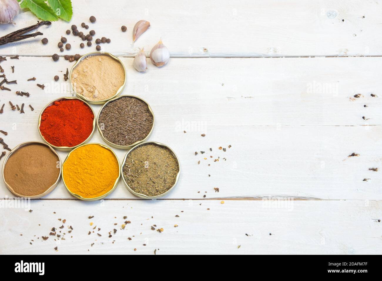 Gewürze verschiedener Art und Farben. Auf dem weißen alten Holztisch. Zutaten, die unserer Küche den richtigen Geschmack verleihen. Stockfoto