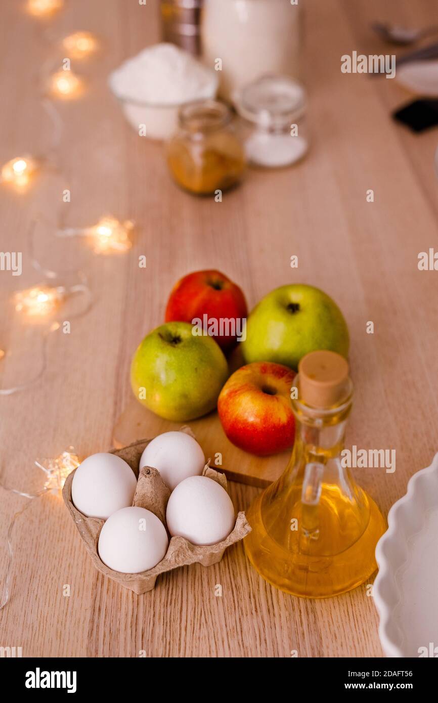 Zutaten für den traditionellen Apfelkuchen: Äpfel, Eier, Butter, Zucker, Zimt und Mehl. Silvesterkonzept für Abendessen Stockfoto