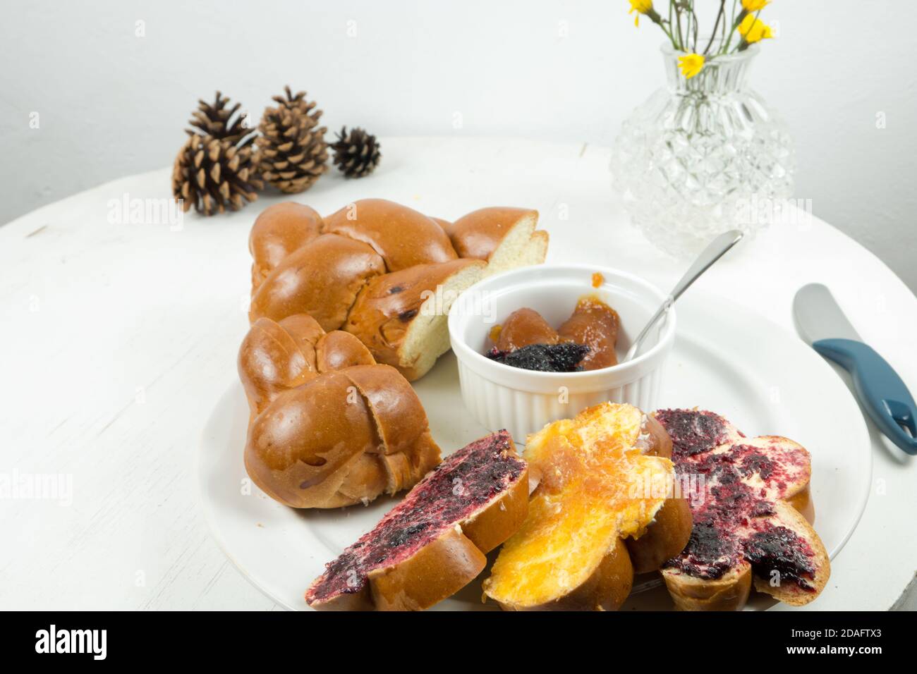 Weihnachtsbäckerei aus der Slowakei. Weihnachtsbrot mit Butter und hausgemachter Marmelade serviert auf alten weißen vintage Holztisch. Dekoriert mit Blumen Stockfoto