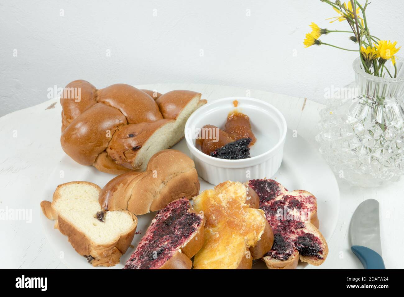 Traditionelles weihnachtsbrot aus der Slowakei. Weihnachts-Backwarenprodukt mit Butter und hausgemachter Marmelade serviert auf alten runden weißen Holztisch. Stockfoto