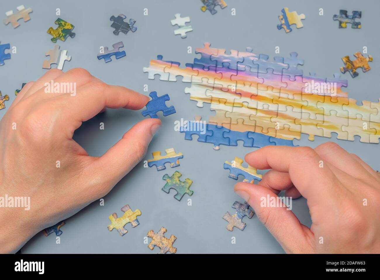 Unvollendete Puzzle. Männliche Hände Verbinden Sie die Teile eines Puzzle. Montage Puzzle. Zeitvertreib, ein Hobby. Spielen Von Calm Board Game Stockfoto