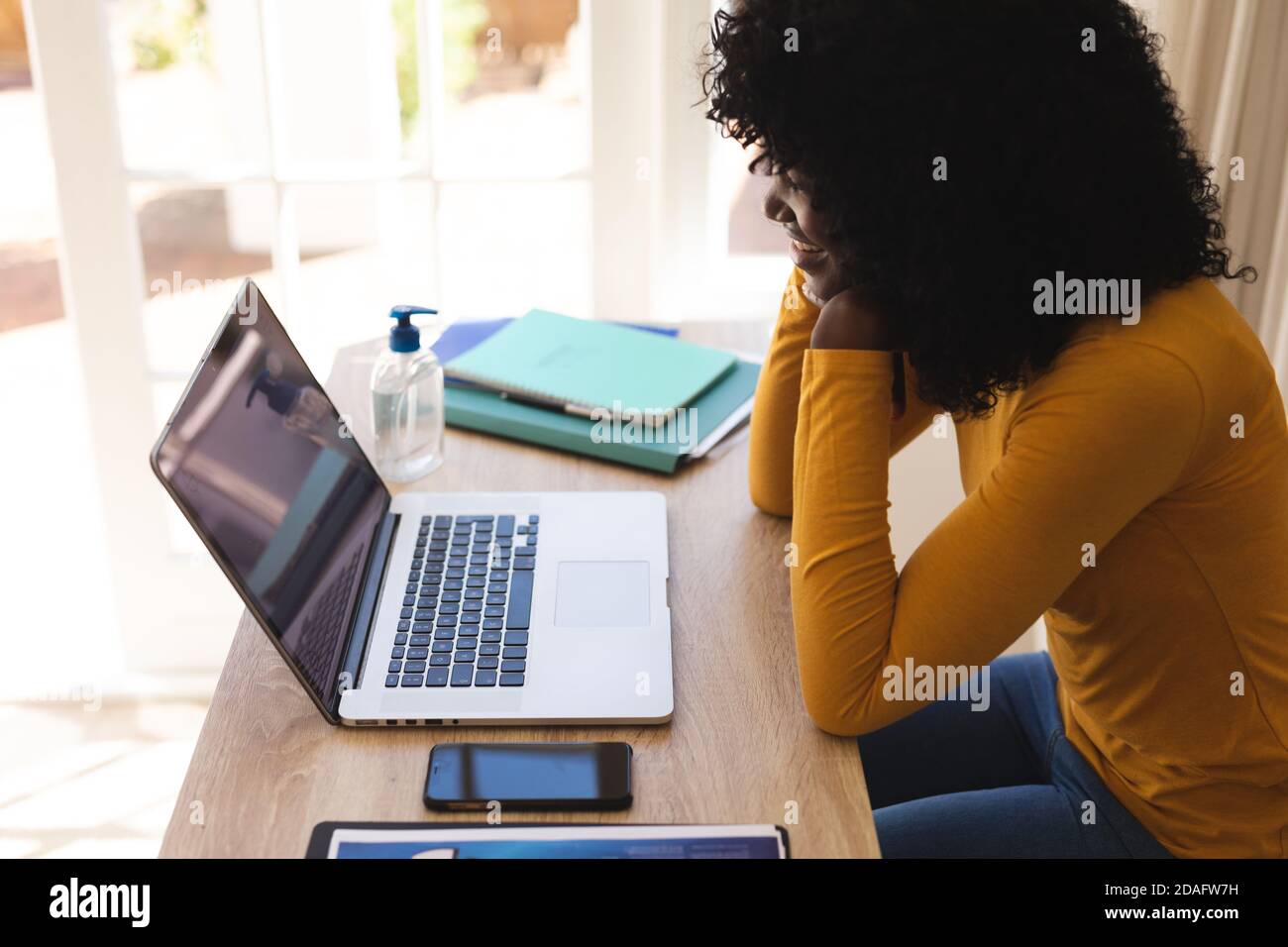afroamerikanische Frau mit einem Video-Chat auf Laptop, während Arbeiten von zu Hause aus Stockfoto