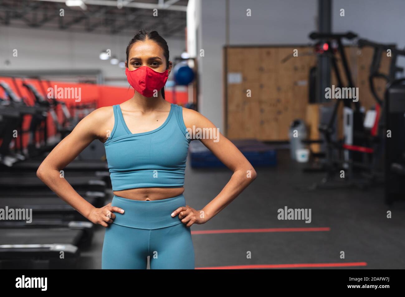 Portrait von fit kaukasischen Frau trägt Gesichtsmaske stehen in Der Fitnessraum Stockfoto