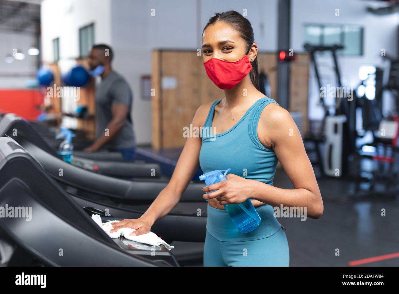 Porträt von fit kaukasischen Frau trägt Gesichtsmaske desinfizieren Herz Maschine vor dem Ausarbeiten in Th Stockfoto