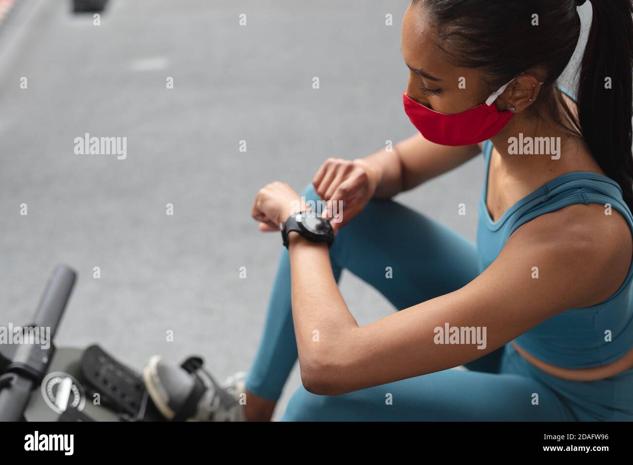 Passen kaukasische Frau trägt Gesichtsmaske mit Smartwatch in der Fitnessraum Stockfoto