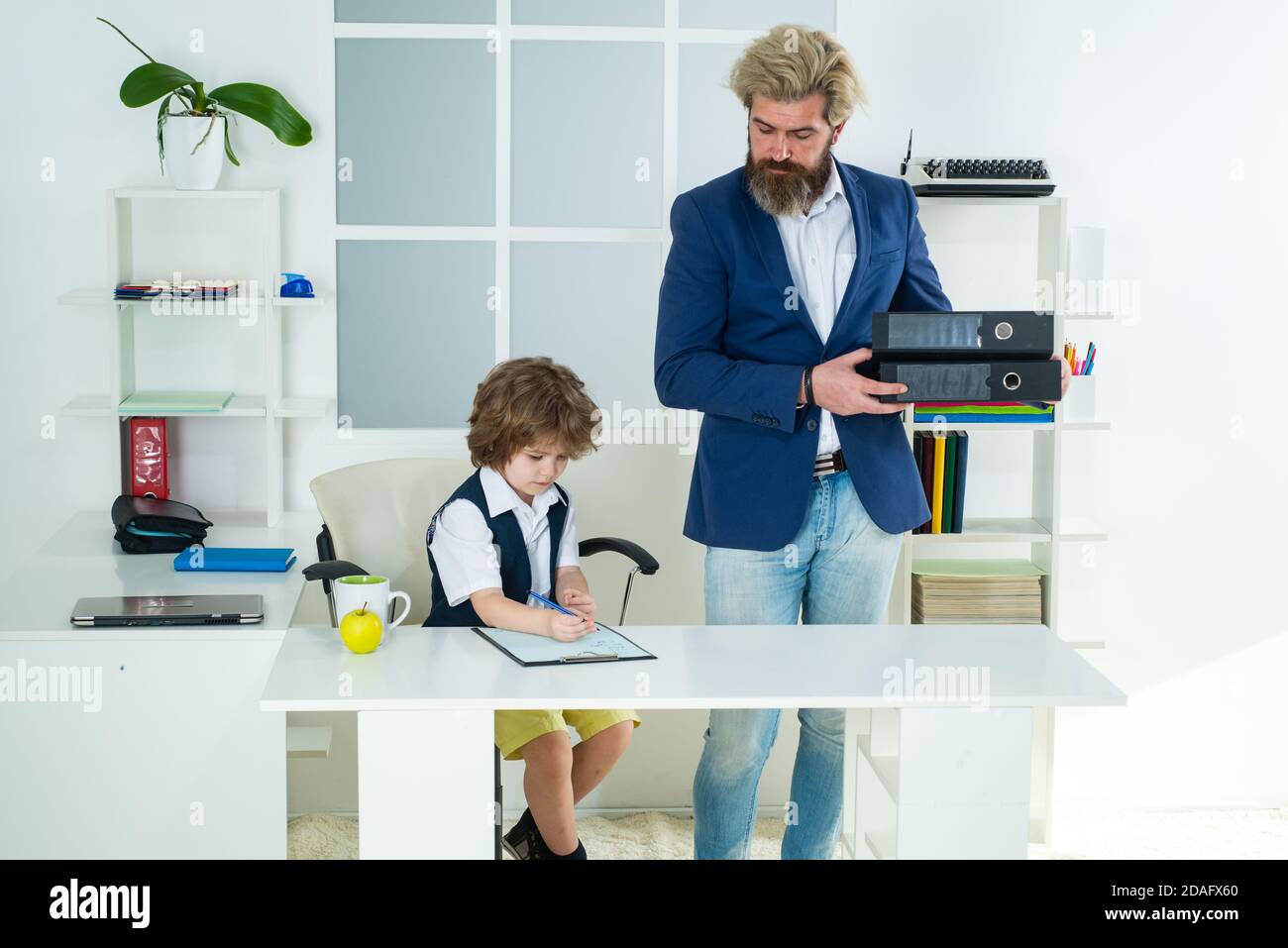 Kleiner Chef. Kleiner Geschäftsmann herrisch Kind arbeitet im Büro. Stockfoto