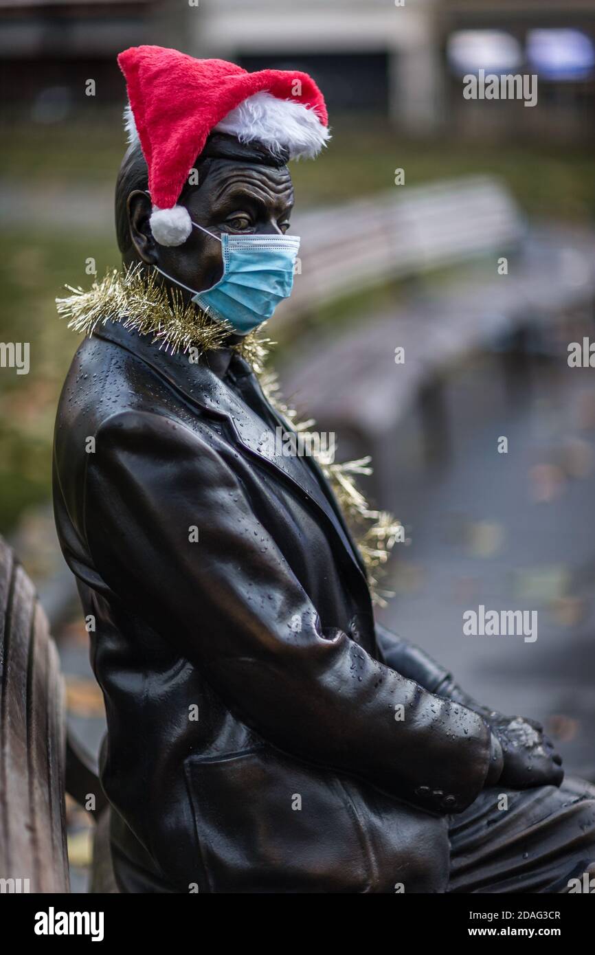 Ein trauriger und einsamer Herr Bean, der eine Maske und einen weihnachtshut trägt, veranschaulicht die Zeiten, in denen wir leben. Stockfoto