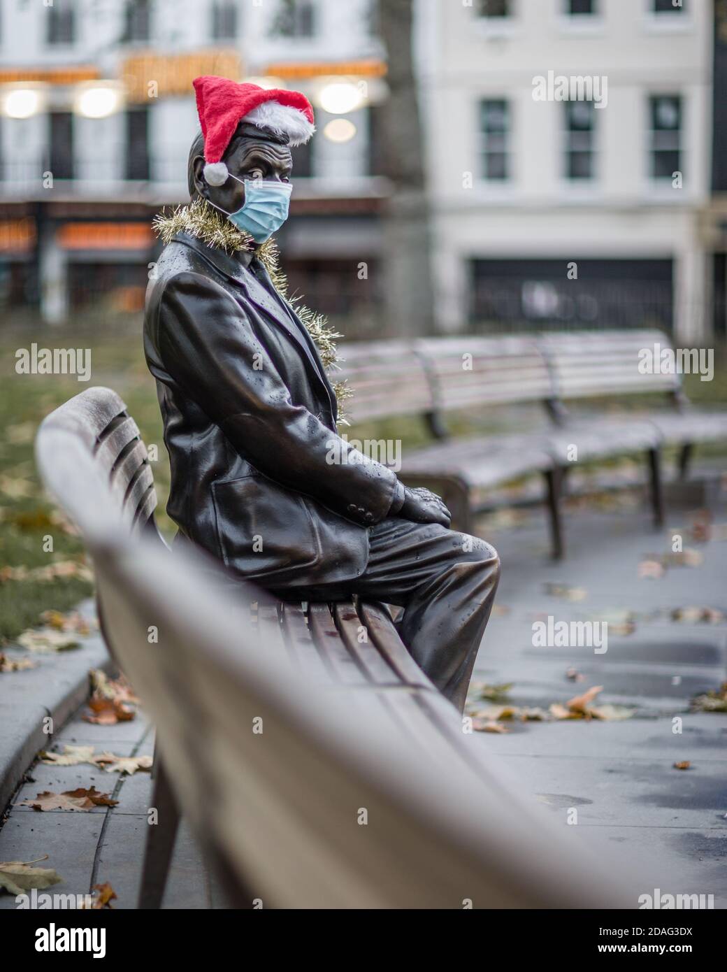 Ein trauriger und einsamer Herr Bean, der eine Maske und einen weihnachtshut trägt, veranschaulicht die Zeiten, in denen wir leben. Stockfoto