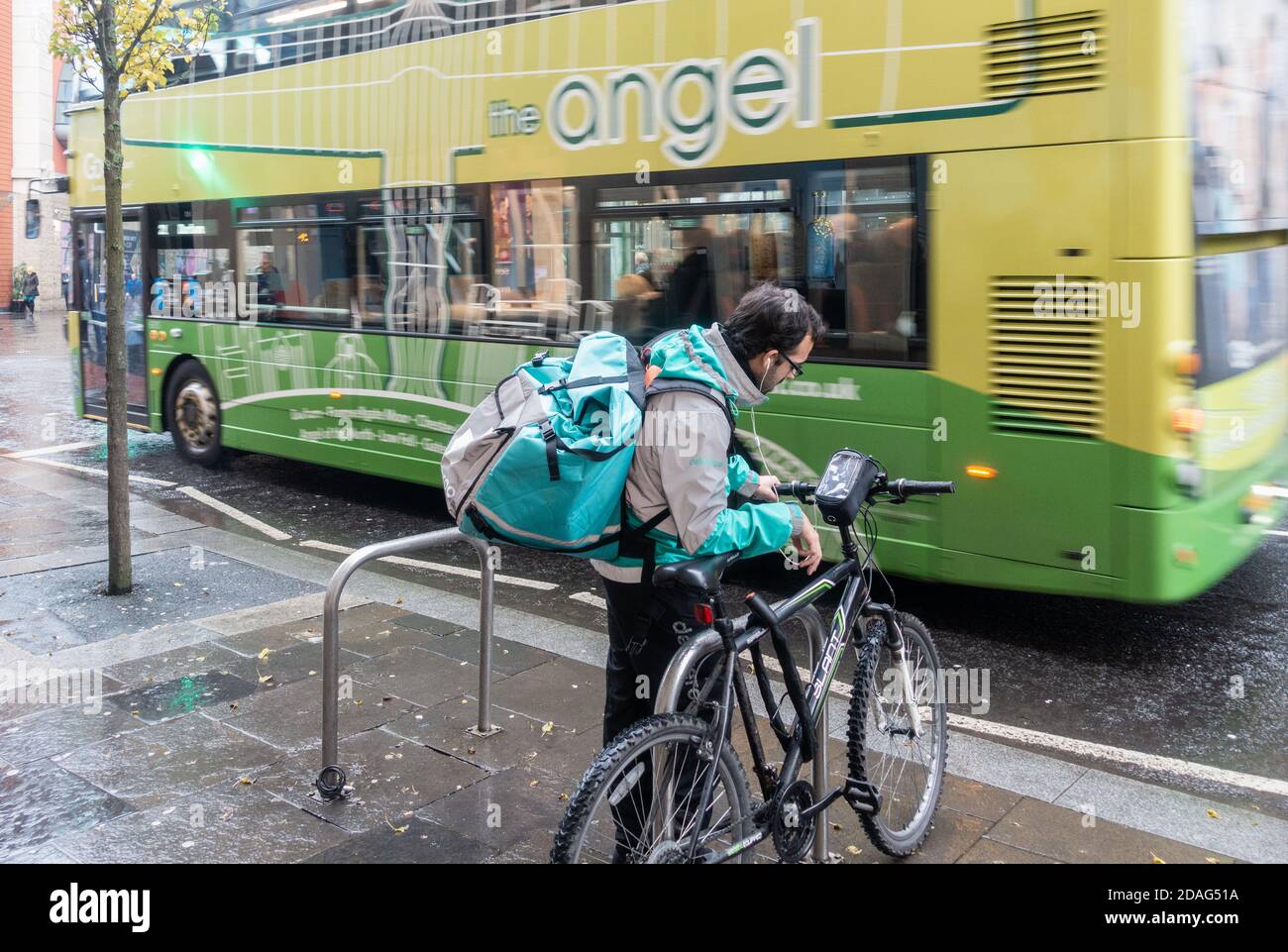 Deliveroo Rider, Kurier mit Fahrrad im Regen in Newcastle upon Tyne, England. VEREINIGTES KÖNIGREICH Stockfoto
