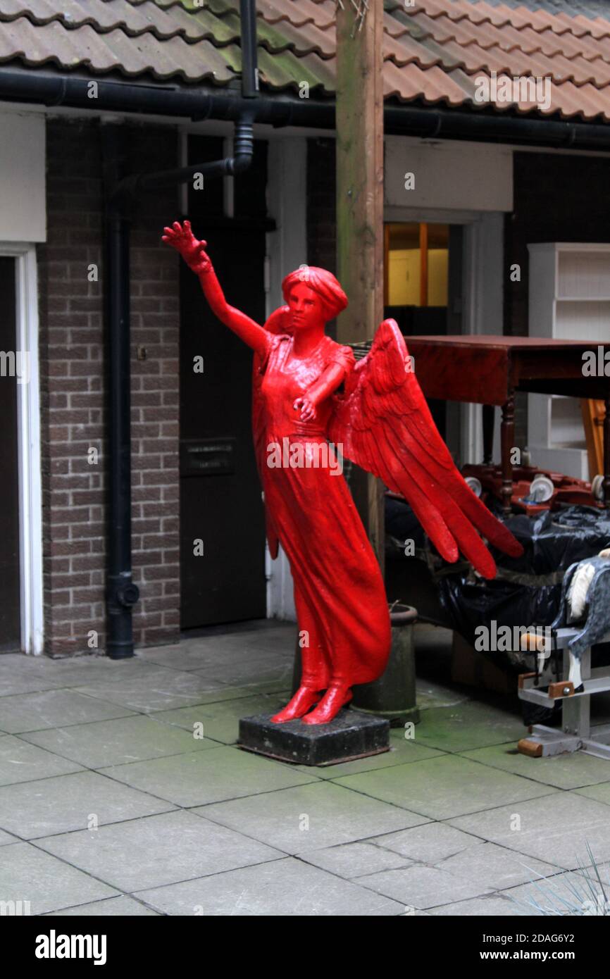The Barra's, Paddys Market, Glasgow, Schottland, Großbritannien, Surreale Objekte auf dem Markt. Ein leuchtend roter Engel in einem Innenhof Stockfoto