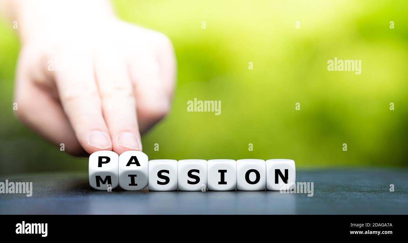Erfüllen Sie Ihre Mission mit Leidenschaft. Hand dreht Würfel und ändert den Namen 'Mission' in 'Leidenschaft'. Stockfoto