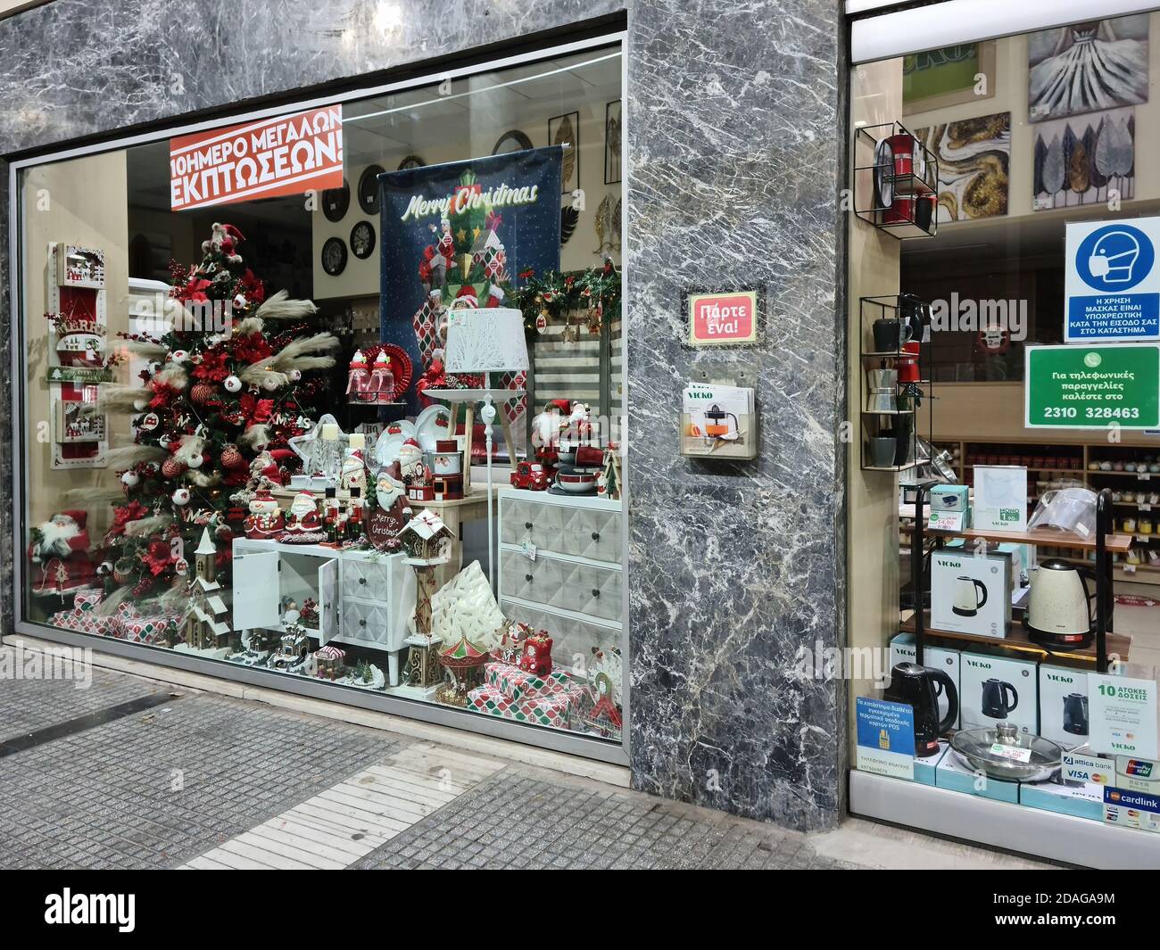 Thessaloniki, Griechenland - 9. November 2020: Hellenic leer Weihnachten Schaufenster. Beleuchtete Nachtansicht des saisonal dekorierten Ladens aufgrund von Maßnahmen des Covid-19 geschlossen. Stockfoto
