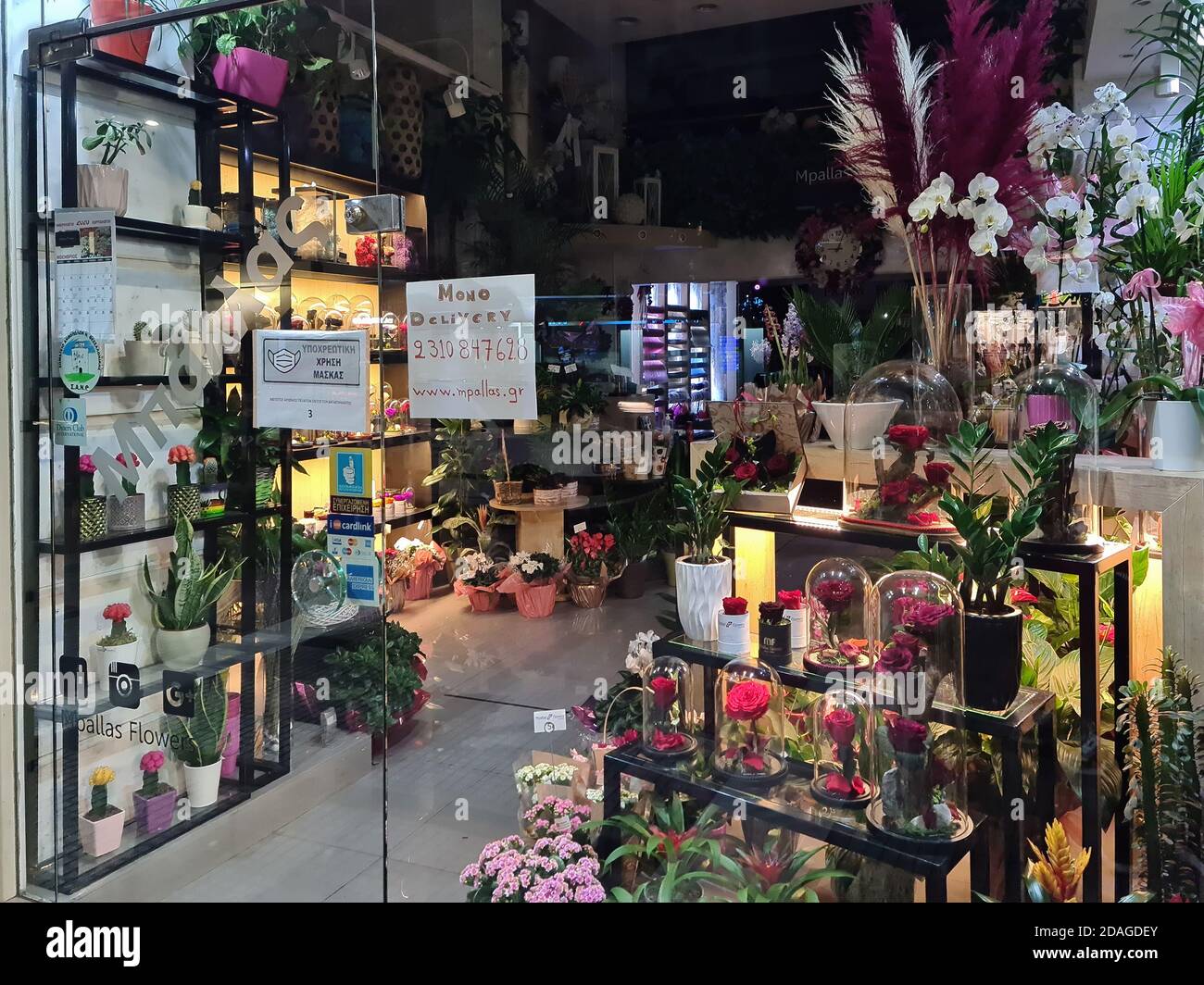 Thessaloniki, Griechenland - 9. November 2020: Hellenic geschlossen Blumen Schaufenster. Beleuchtete Nachtansicht von dekorierten Laden mit Lieferoption nur, aufgrund covid-19 Maßnahmen. Stockfoto