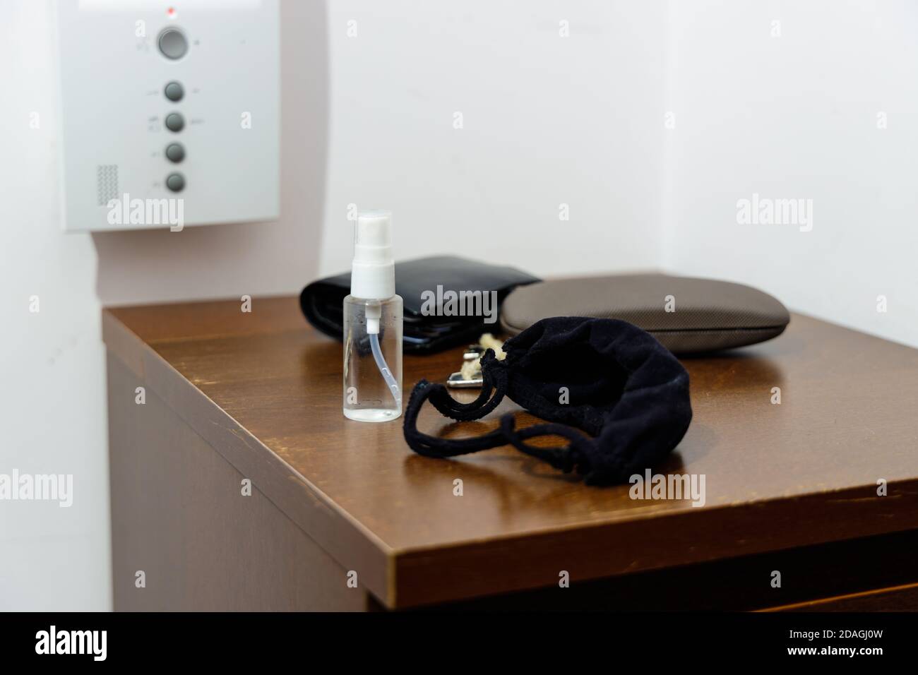 Pandemie-Setup bereit vor dem Verlassen des Hauses: Gesichtsmaske und Desinfektionsmittel in kleiner handlicher Flasche Stockfoto