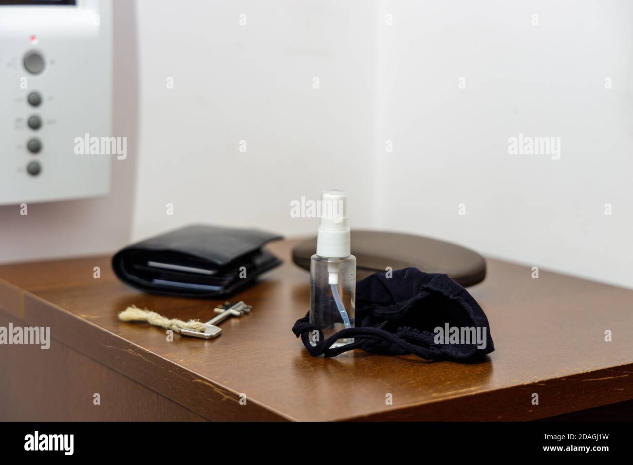 Pandemie-Setup bereit vor dem Verlassen des Hauses: Gesichtsmaske und Desinfektionsmittel in kleiner handlicher Flasche Stockfoto