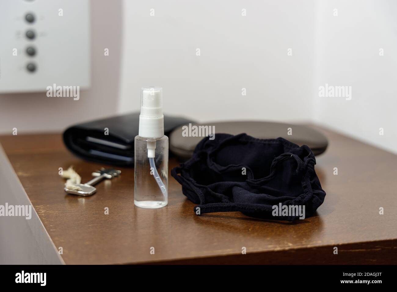 Pandemie-Setup bereit vor dem Verlassen des Hauses: Gesichtsmaske und Desinfektionsmittel in kleiner handlicher Flasche Stockfoto
