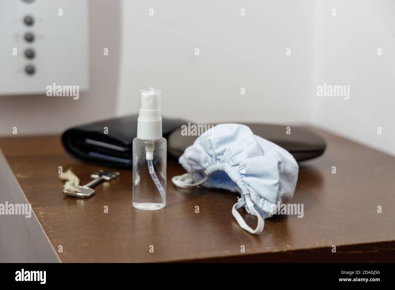 Pandemie-Setup bereit vor dem Verlassen des Hauses: Gesichtsmaske und Desinfektionsmittel in kleiner handlicher Flasche Stockfoto