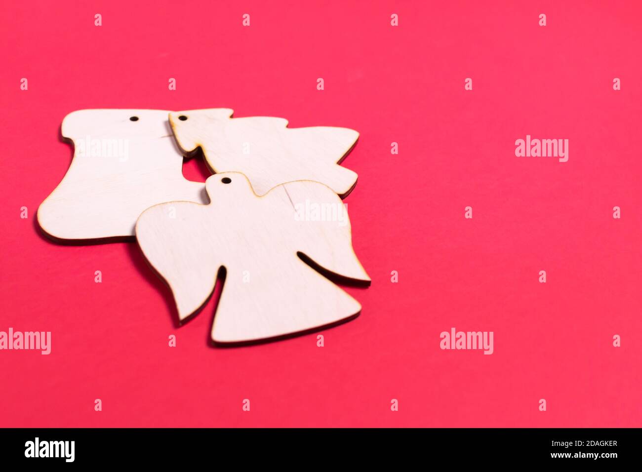 Weihnachtsspielzeug aus Holz auf rotem Hintergrund. Engel, Stiefel, Baum. Natürliches Weihnachtsdekor-Konzept. Speicherplatz kopieren. Draufsicht. Stockfoto