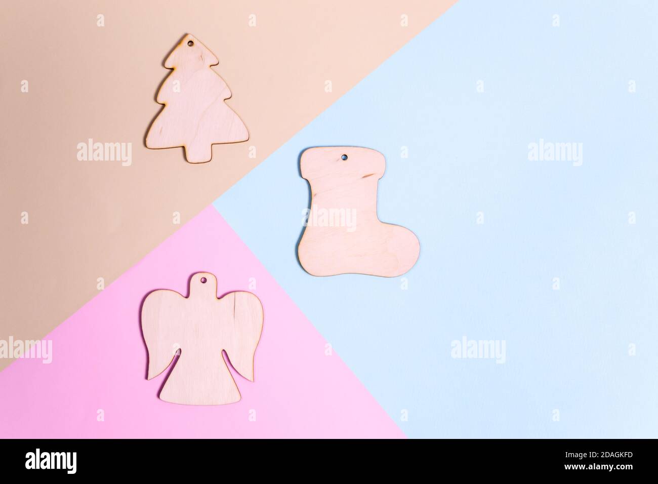 Weihnachtsbaumschmuck aus Holz auf farbigem Hintergrund. Natürliches Weihnachtsdekor-Konzept. Draufsicht. Stockfoto