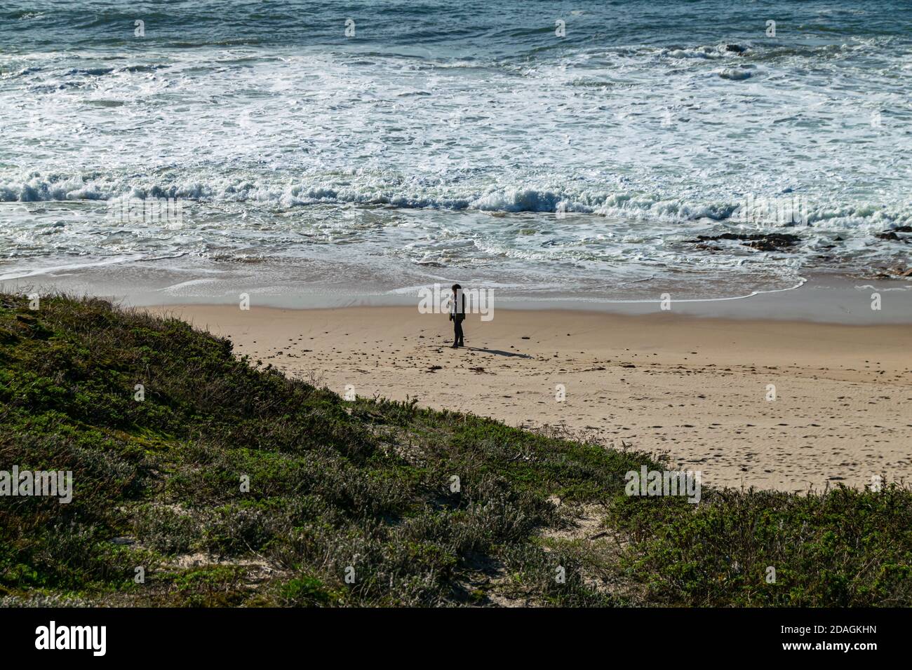 Allein eine Frau am Strand, die einige fotografiert Felsen im Sand Stockfoto