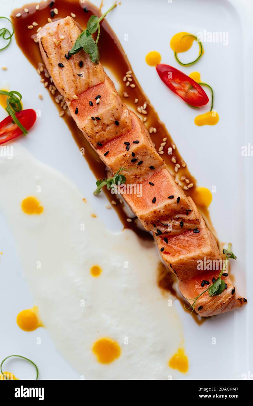 Gegrillter Lachs mit Sauce auf einem weißen Teller Stockfoto