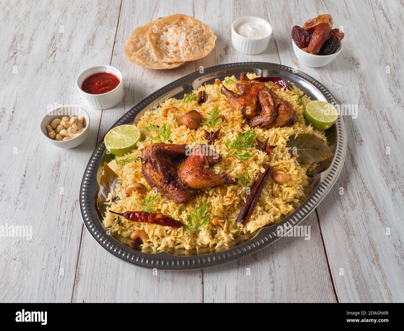 Chicken Mandi mit Datteln auf einem Holztisch. Arabische Küche. Draufsicht. Stockfoto