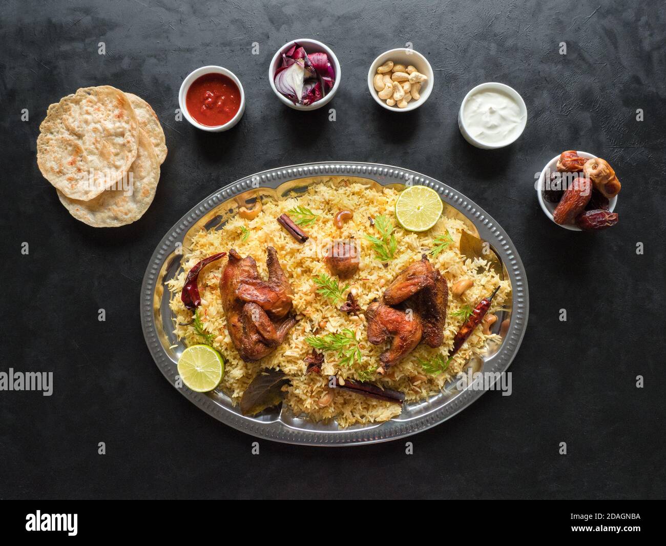 Chicken Mandi mit Datteln auf einem schwarzen Tisch. Arabische Küche. Draufsicht. Stockfoto