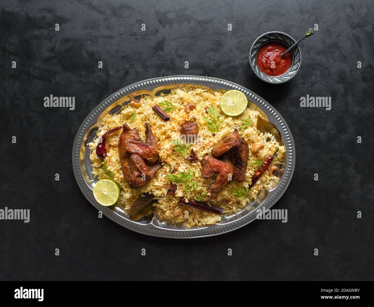 Chicken Mandi mit Datteln auf einem schwarzen Tisch. Arabische Küche. Draufsicht. Stockfoto