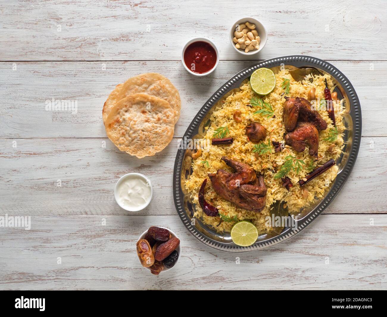 Chicken Mandi mit Datteln auf einem weißen Tisch. Arabische Küche. Draufsicht. Stockfoto