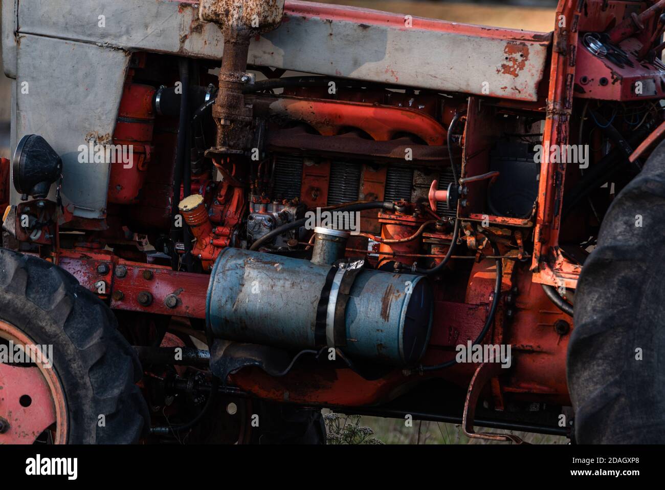 Alte silberfarben lackierte Dieseltank auf roten vintage russischen Traktor Motor sichtbar Verdrahtung Rost und Öltropfen im sonnigen Herbst Tag im ländlichen Bulgarien Stockfoto