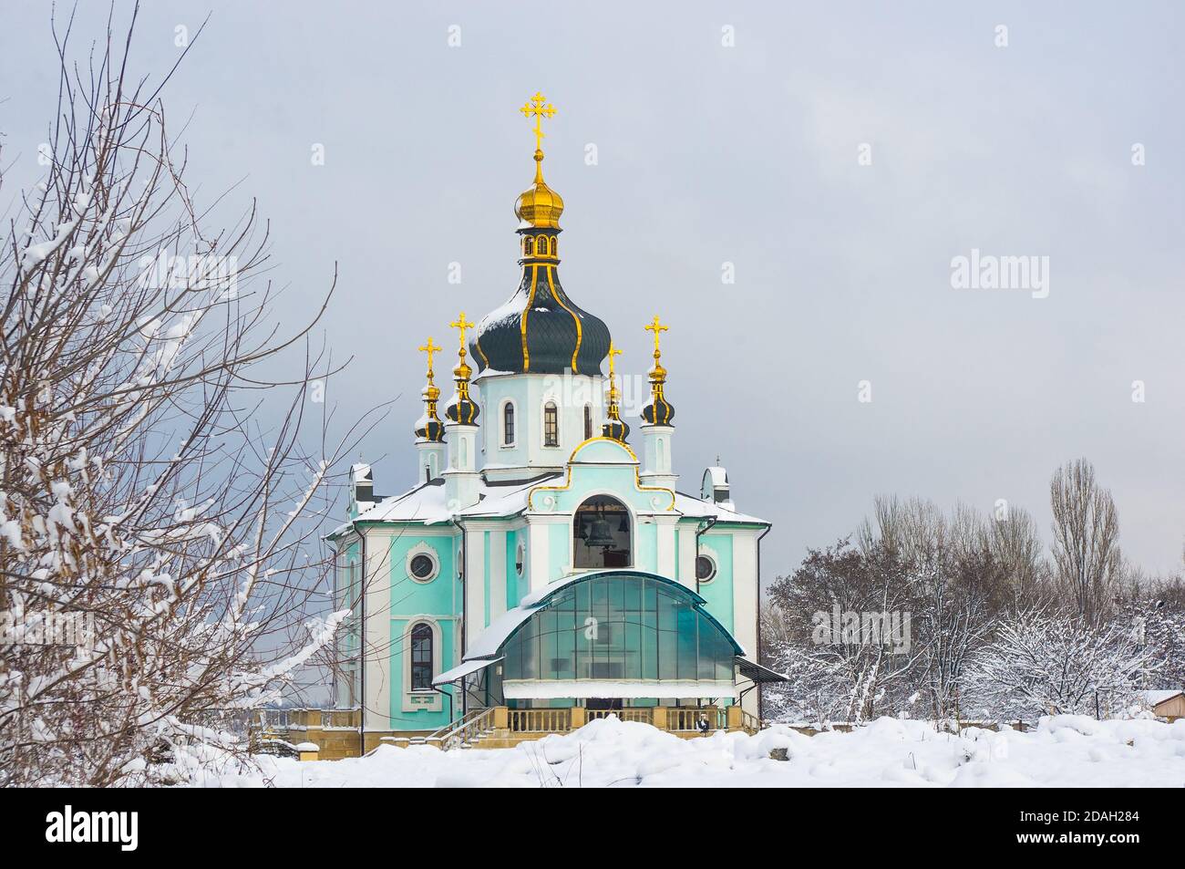 Winterlandschaft - Orthodoxe Kirche im Schnee unter Bäumen An einem kalten frostigen Tag Stockfoto