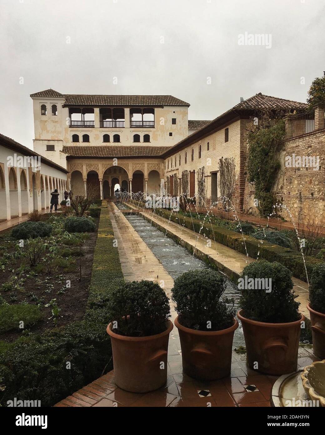 Reflektierender Pool mit Sträuchern an der Seite und eine Aussicht Von Bogentüren im Hintergrund in den Generalife Gärten An der Alhambra Palast und Festung com Stockfoto