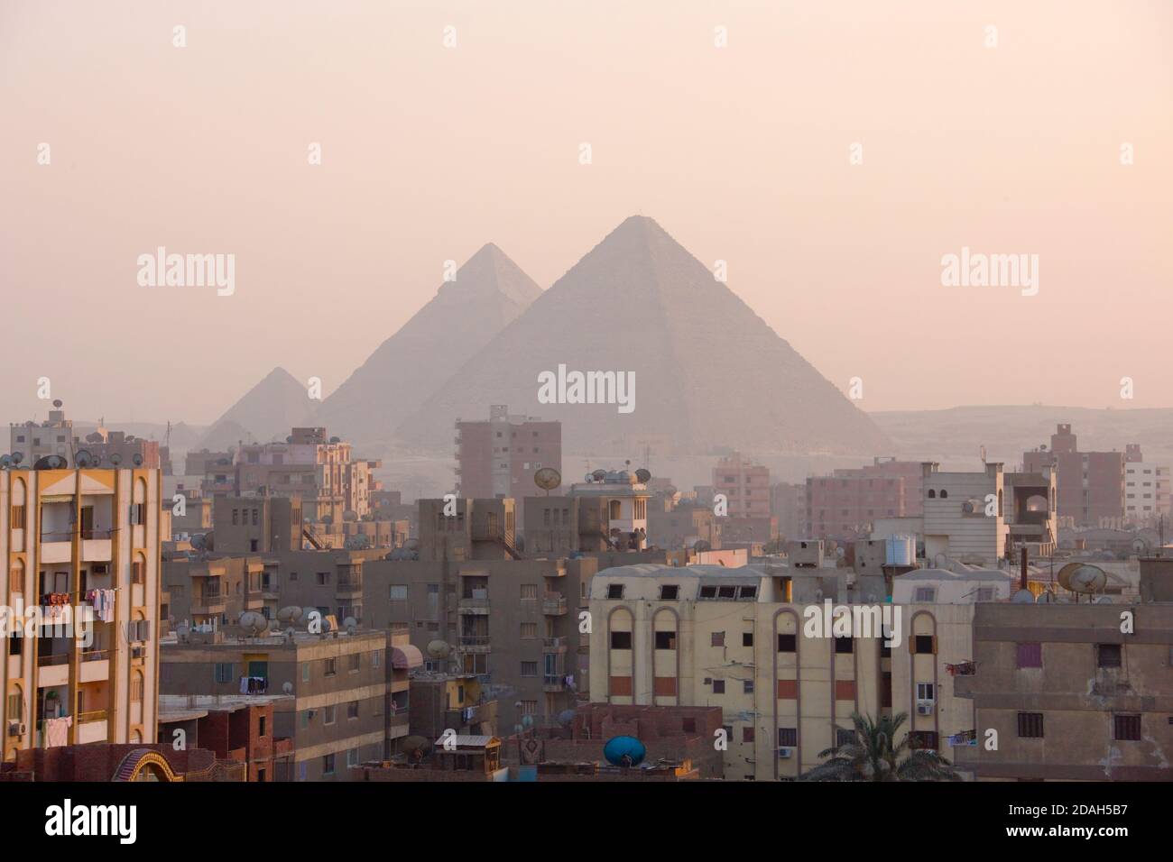 Stadt Gizeh mit der Großen Pyramide im Hintergrund bei Sonnenaufgang, UNESCO-Weltkulturerbe, Gizeh, Kairo Governorate, Ägypten Stockfoto