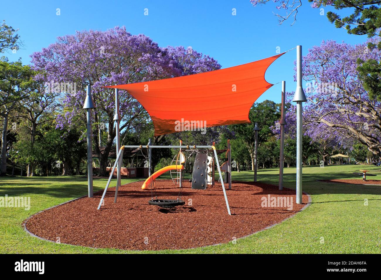 Spielplatz im See Park, Grafton, NSW, Australien, mit orangefarbenem Sonnenschirm. Stockfoto