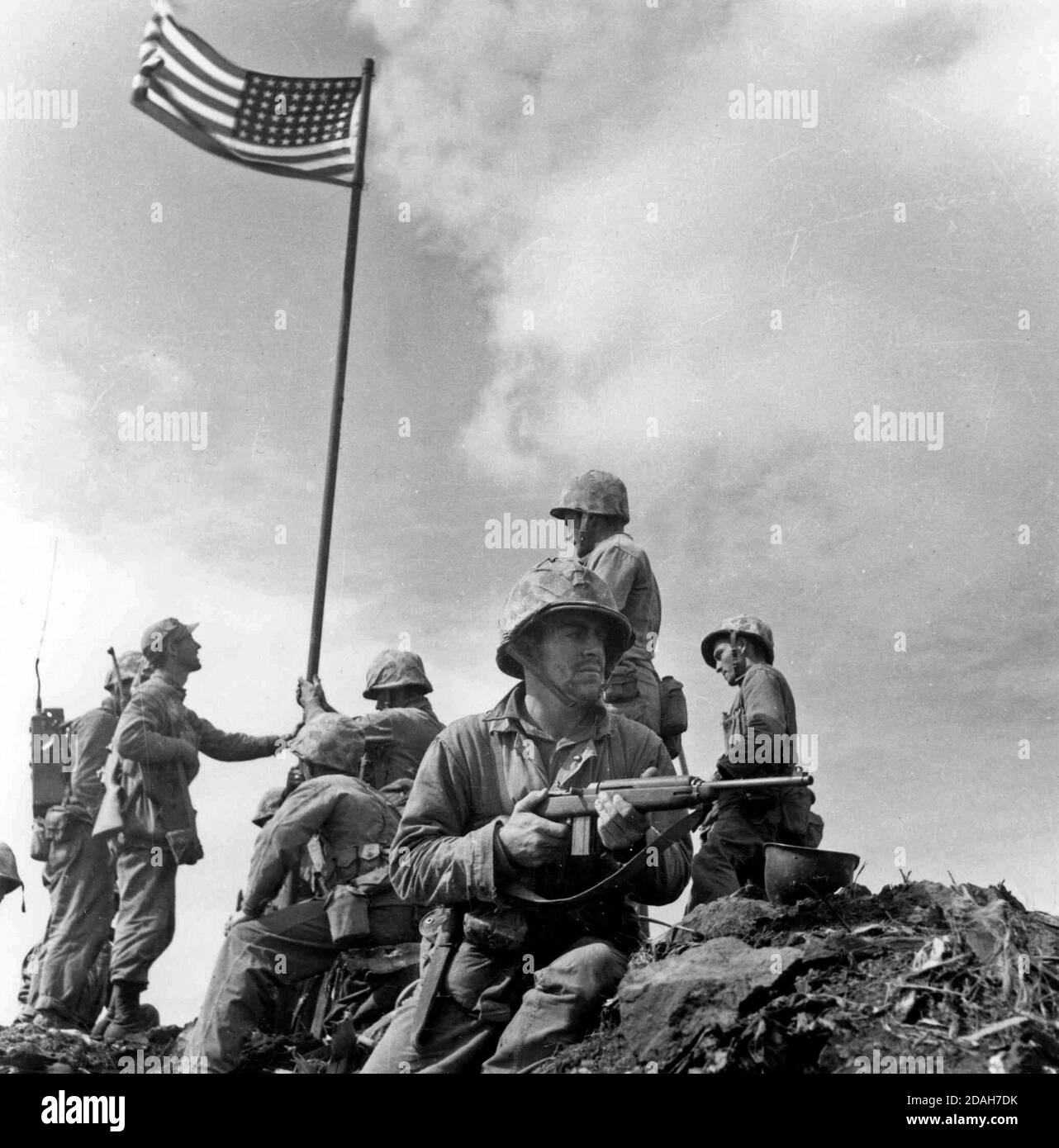 Eine kleine Flagge, die vom 2. Bataillon, 28. Marines getragen wird, wird auf dem Berg Suribachi um 10:20 Uhr am 23. Februar 1945 gepflanzt. Offizielles NAVY-Foto. Dies ist die erste Flagge, die auf dem Gipfel des Mt. Suribachi. Das berühmte Fahnenraising-Foto wurde aufgenommen, als die zweite Flagge später an diesem Tag aufgesetzt wurde. Dieses Foto wurde von Leathernecks Lou Lowery aufgenommen. Stockfoto
