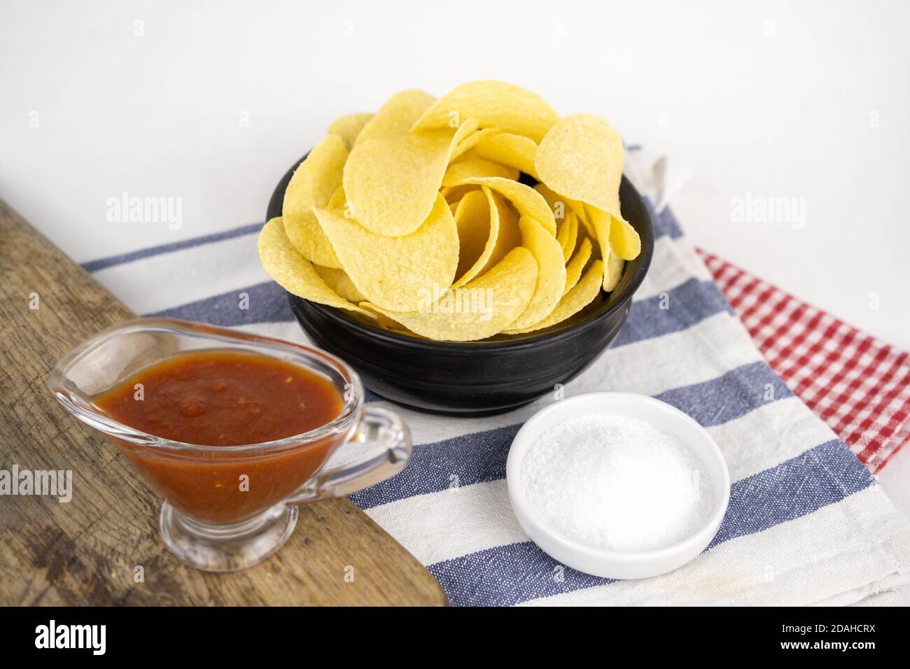 Pommes in einer Holzschüssel mit Grillsauce und Salz Stockfoto