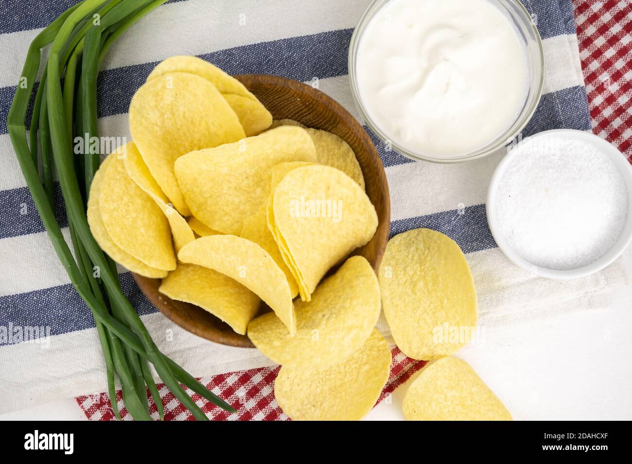 Pommes in einer Holzschüssel mit Sauerrahm und grüner Zwiebel. Stockfoto