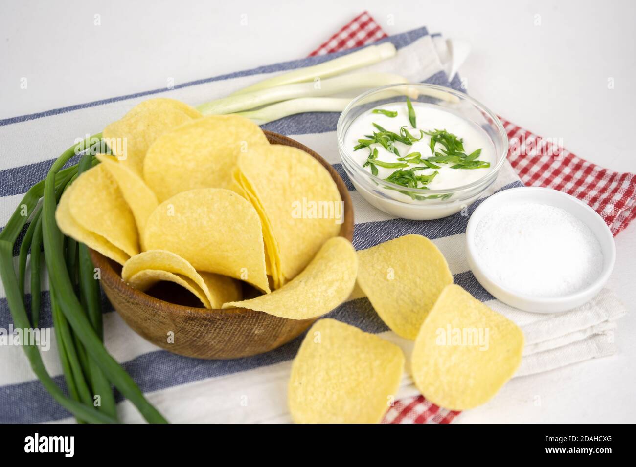 Pommes in einer Holzschüssel mit Sauerrahm und grüner Zwiebel. Stockfoto