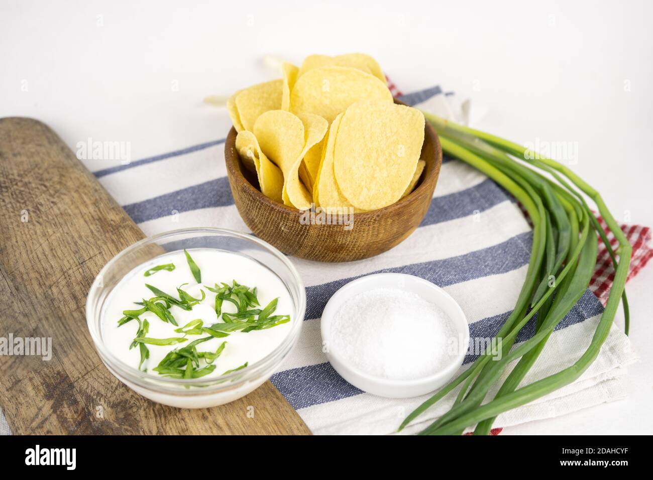 Pommes in einer Holzschüssel mit Sauerrahm und grüner Zwiebel. Stockfoto