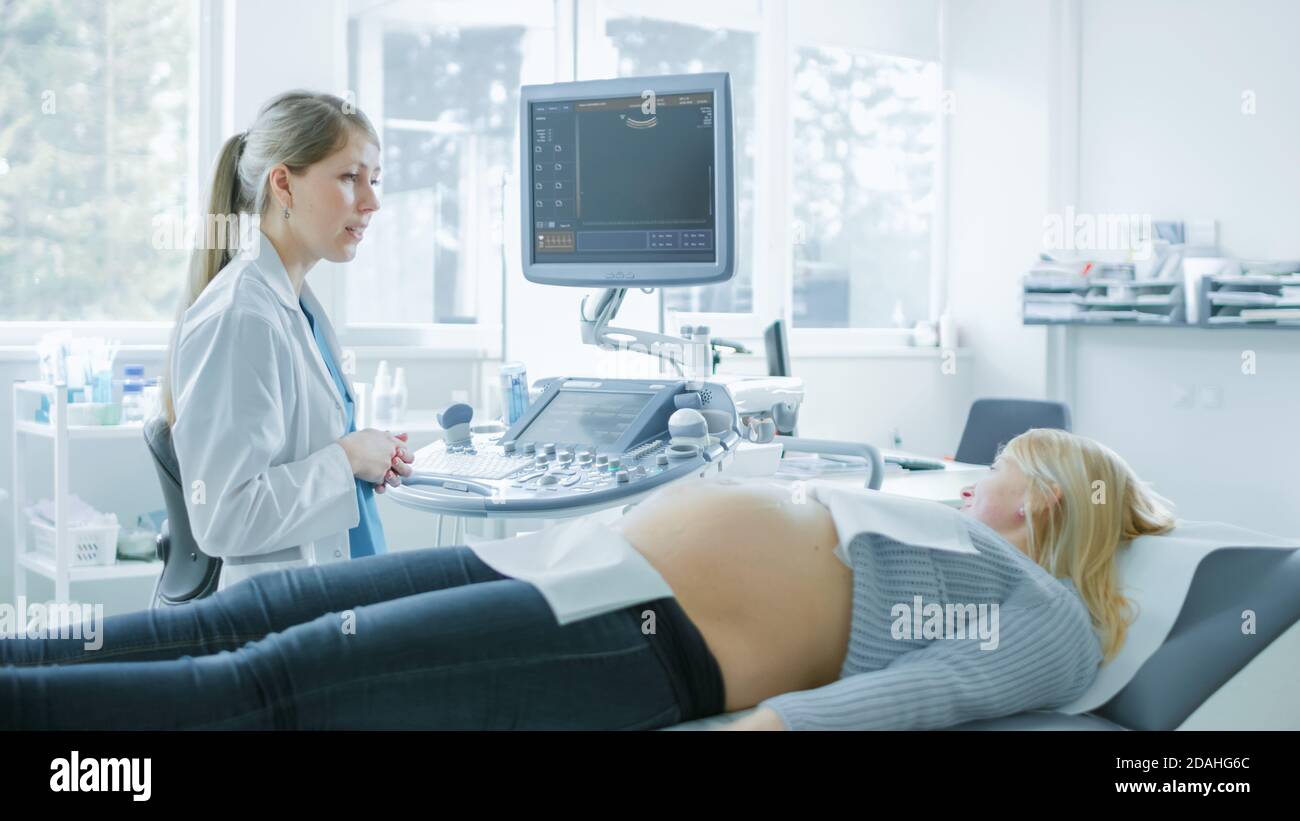 Im Krankenhaus, schwangere Frau bekommen Ultraschall-Sonogramm-Scan, Geburtshelfer erklärt Verfahren. Glückliche Frau wartet auf ihr erstes Baby. Stockfoto