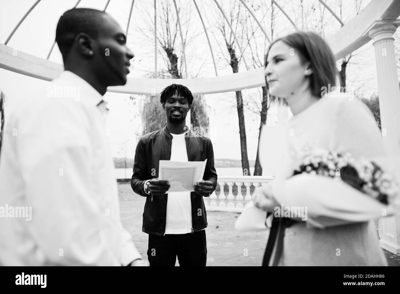 Hochzeit Verlobungszeremonie mit Pastor. Glückliches multiethnisches Paar in Liebesgeschichte. Beziehungen von afrikanischem Mann und weißer europäerin. Stockfoto