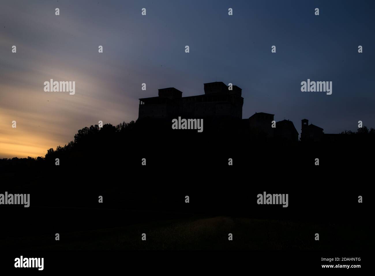Landschaftlich lange Exposition Silhouette Ansicht der berühmten mittelalterlichen italienischen Burg während eines einzigartigen Sonnenuntergangs, Torrechiara, Parma, Italien Stockfoto