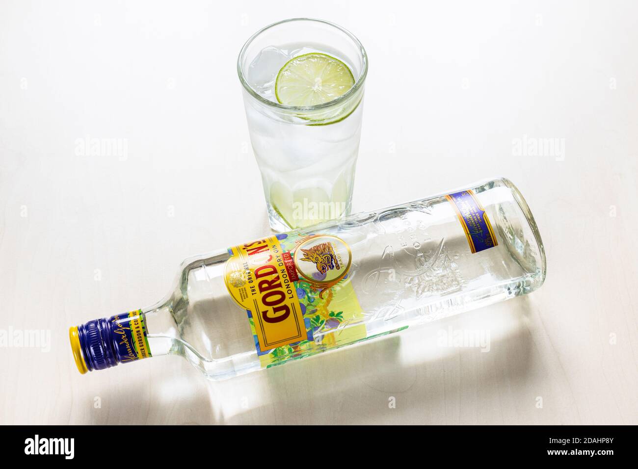 MOSKAU, RUSSLAND - 4. NOVEMBER 2020: Oben liegende Flasche Gordon's London Dry Gin und Gin und Tonic Cocktail im Highballglas auf hellbraunem B Stockfoto