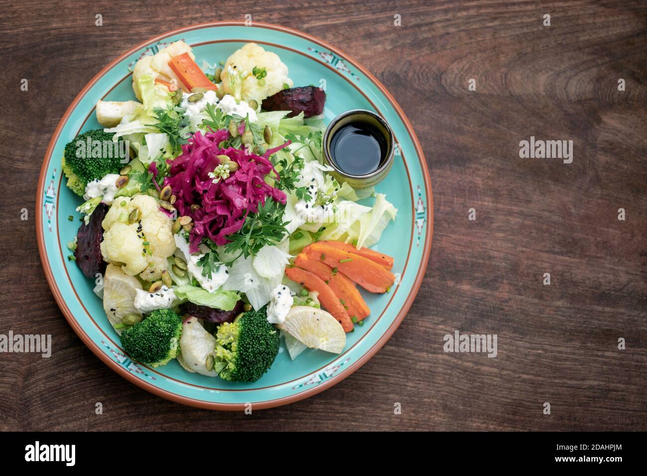 Rustikaler Hüttensalat mit gesundem, gedünstetem und frischem Gemüse Auf buntem Teller Stockfoto