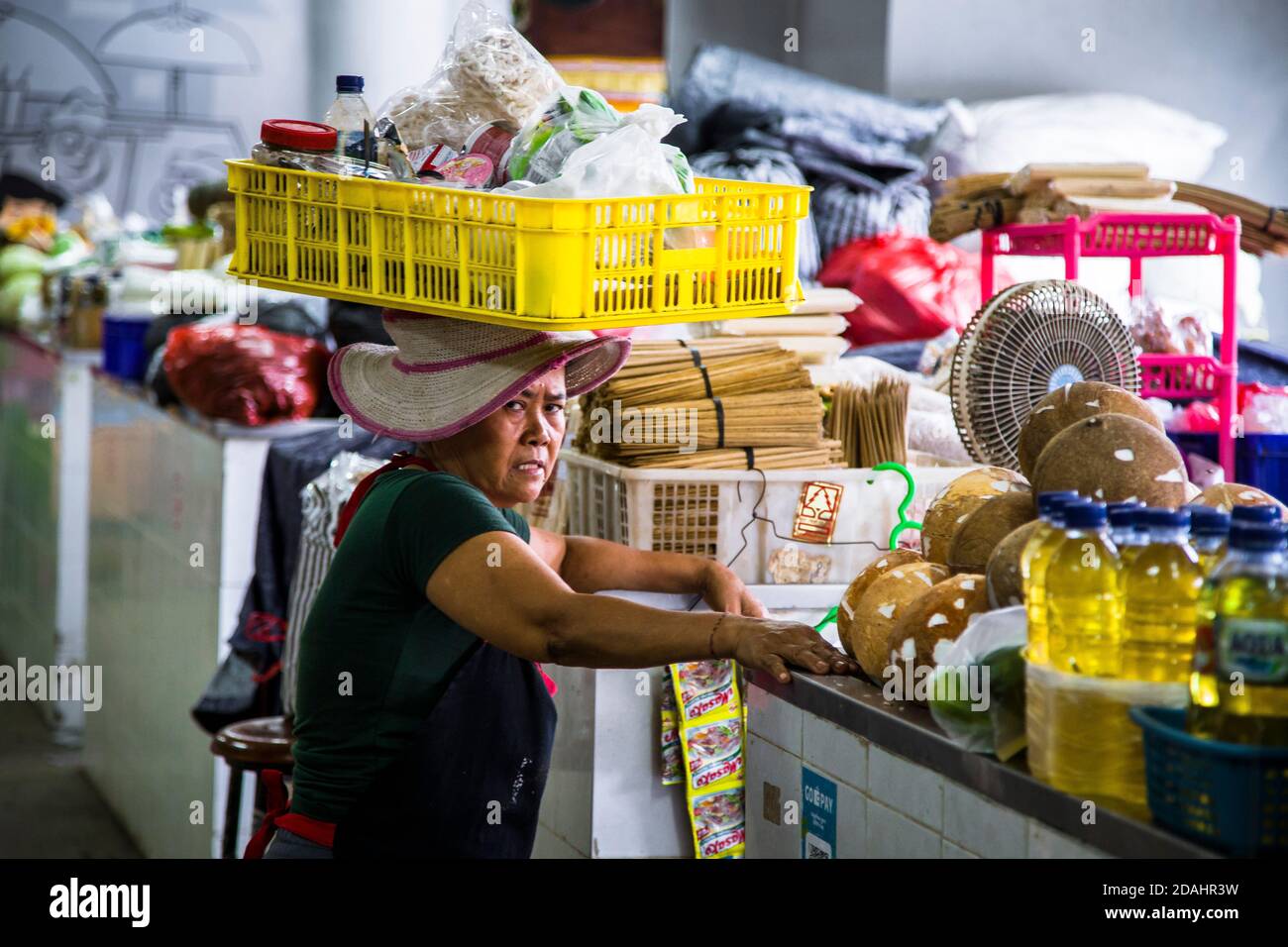 Denpasar, Bali, Indonesien - 8. AUGUST 2019 : neugieriges Porträt einer Frau, die einen Korb auf dem Kopf bringt. Stockfoto