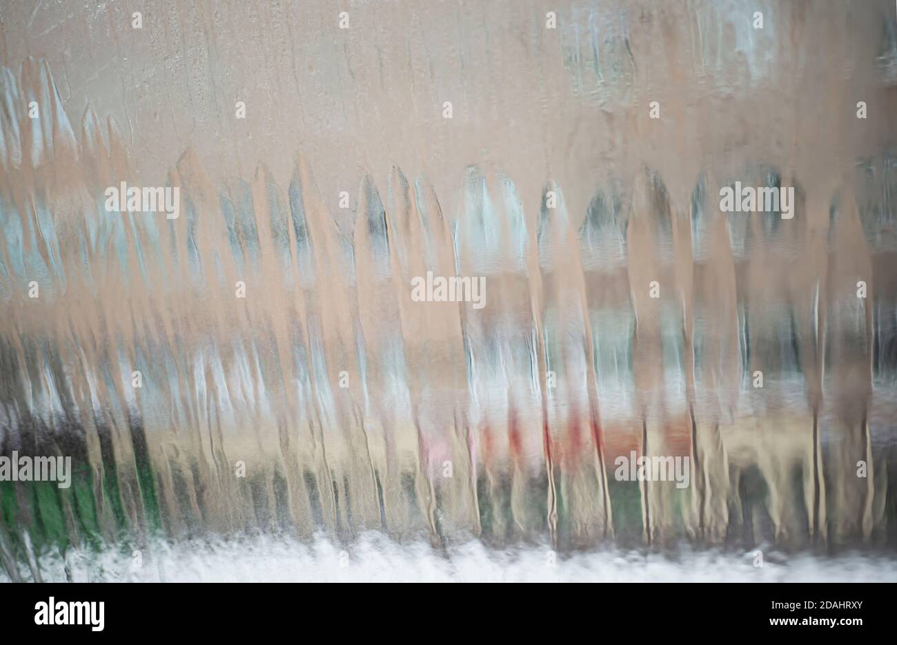 Das Stadthaus ist durch das eisige Glas sichtbar. Wassertropfen laufen das Fenster hinunter. Stadt langweilige Hintergründe. Stockfoto Das Stadthaus ist durch das eisige Glas sichtbar. Wassertropfen laufen das Fenster hinunter. Stadt langweilige Hintergründe. Stockfoto